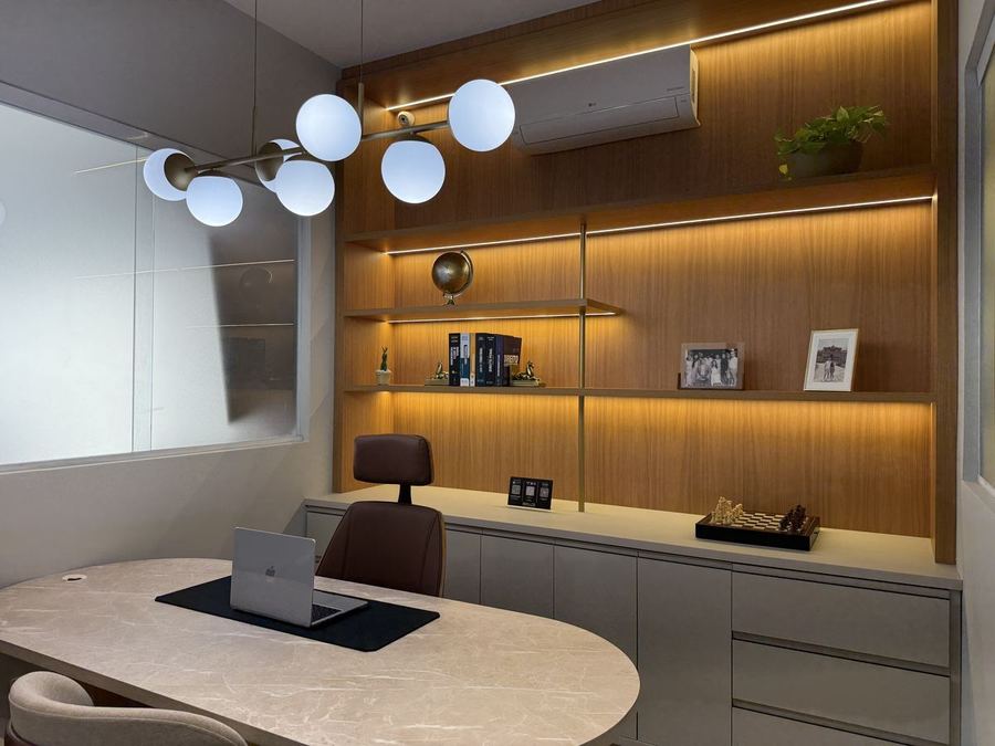 Sala de atendimento com estante de madeira iluminada